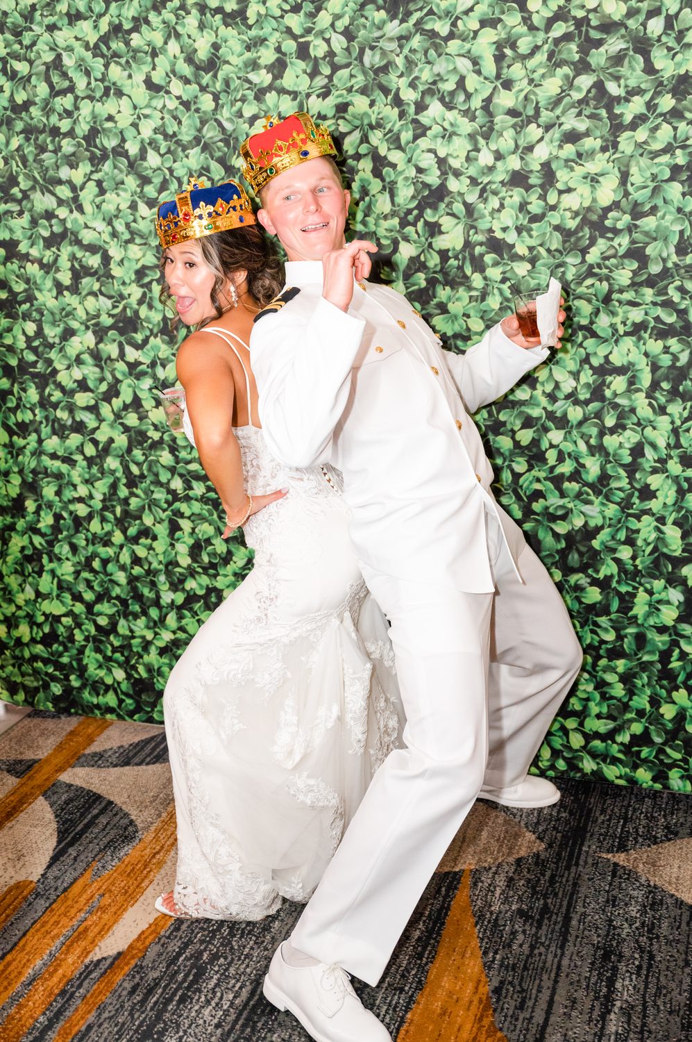 Open-air photo booth with a backdrop and props at a wedding