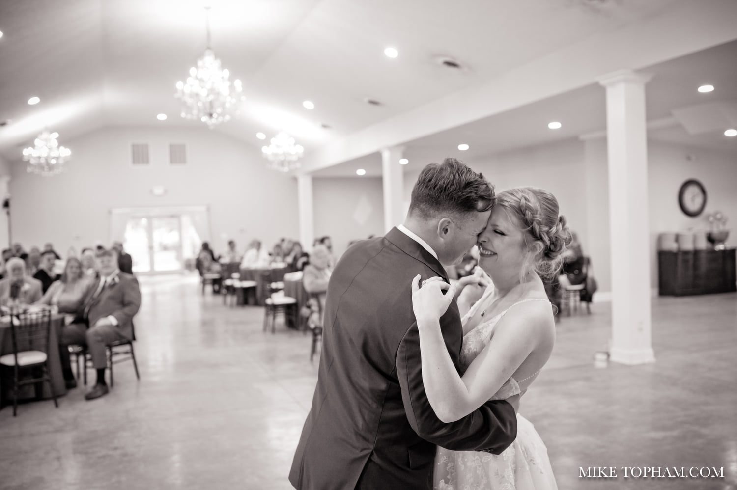 Couple sharing a first dance in a spotlit ballroom