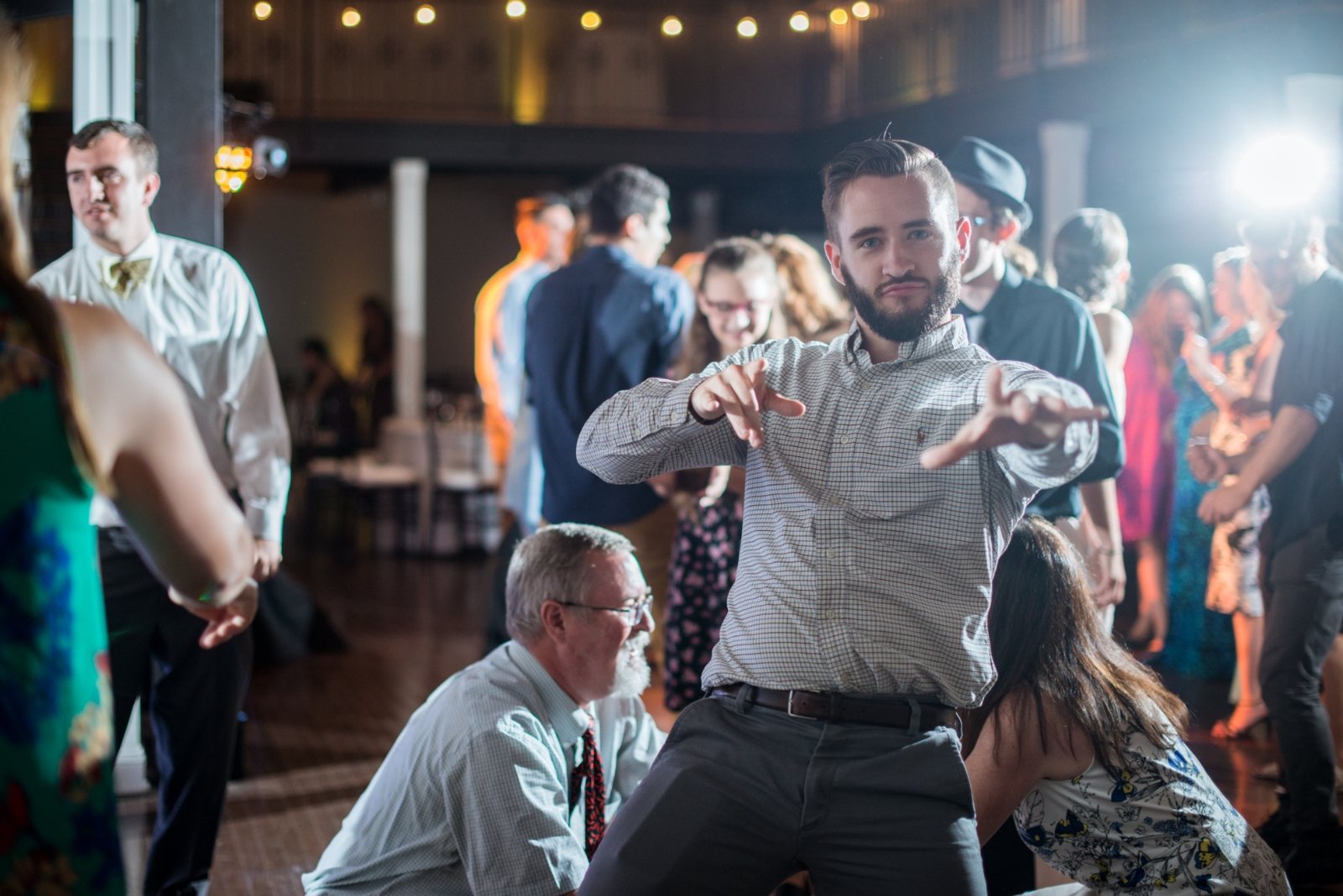 Guest mid-move on a crowded dance floor under string lights