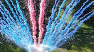 Pink and blue smoke shooting up over a lawn
