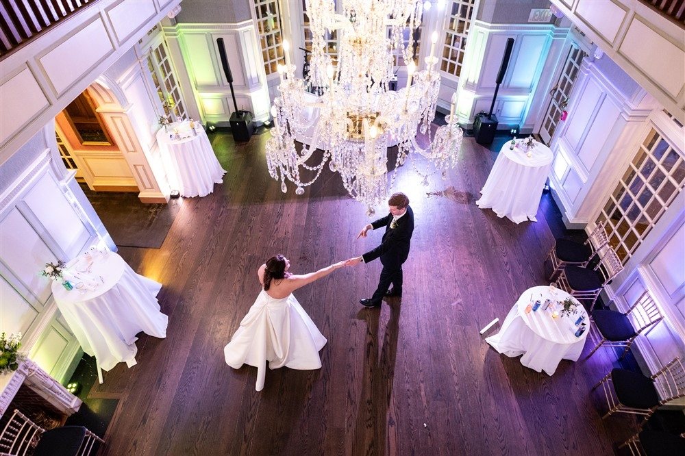 Couple dancing alone beneath a crystal chandelier in a ballroom