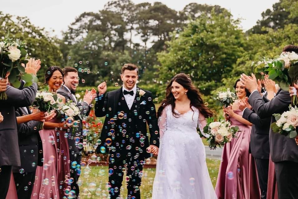 Newlyweds walking through a bubble send-off lined with their wedding party